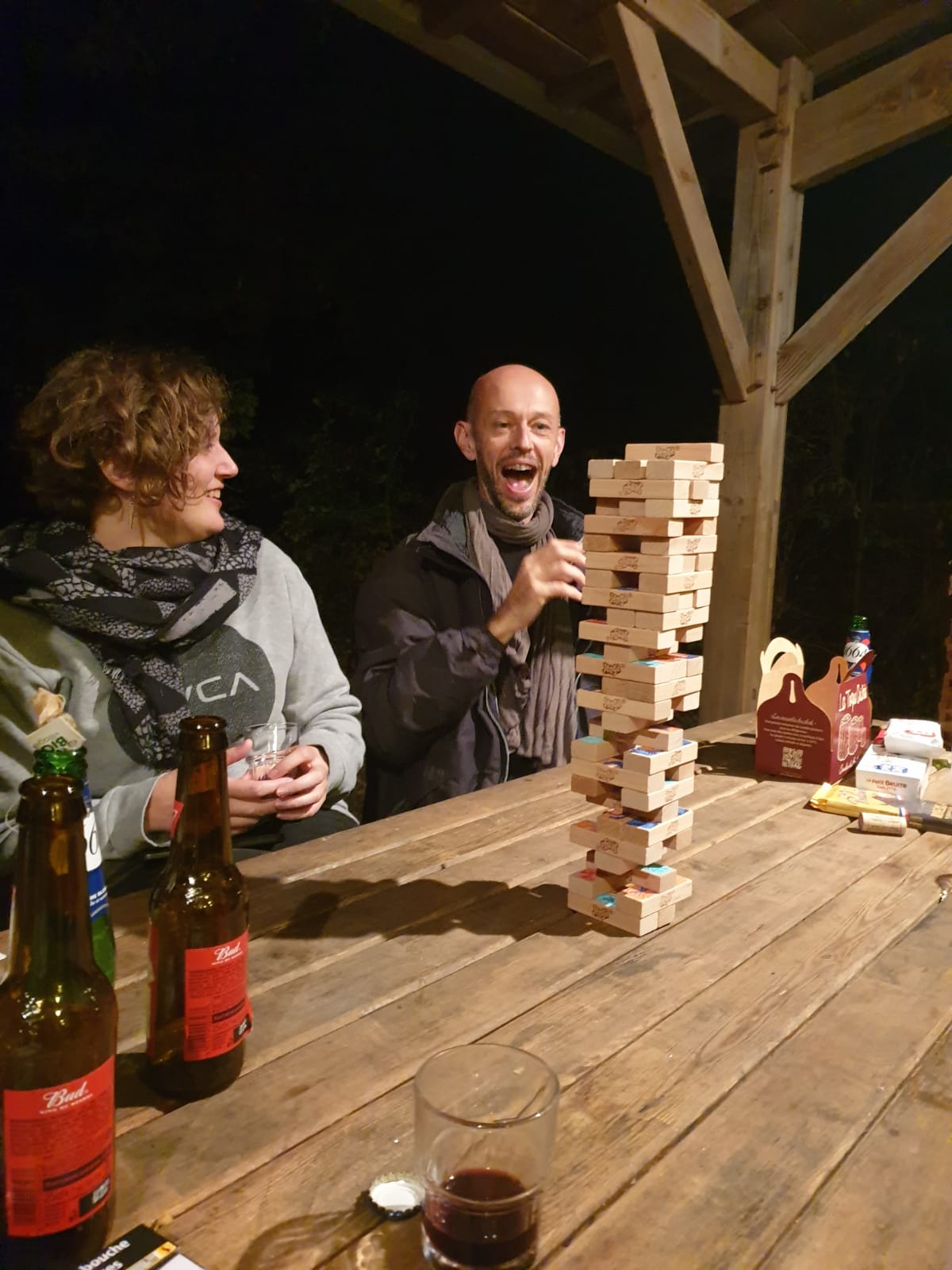 Un miembro de la cooperativa se ríe mientras otro da un giro especialmente tenso durante una partida de jenga